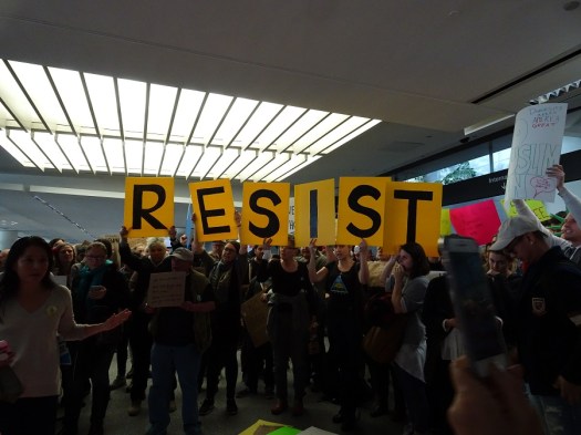resist-sign-with-large-crowd-at-sfo-1-29-17-small