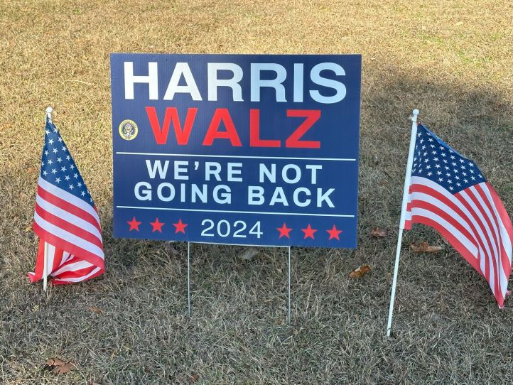A photo of an election sign on a lawn for Harris-Walz with the statement "We're not going back."
